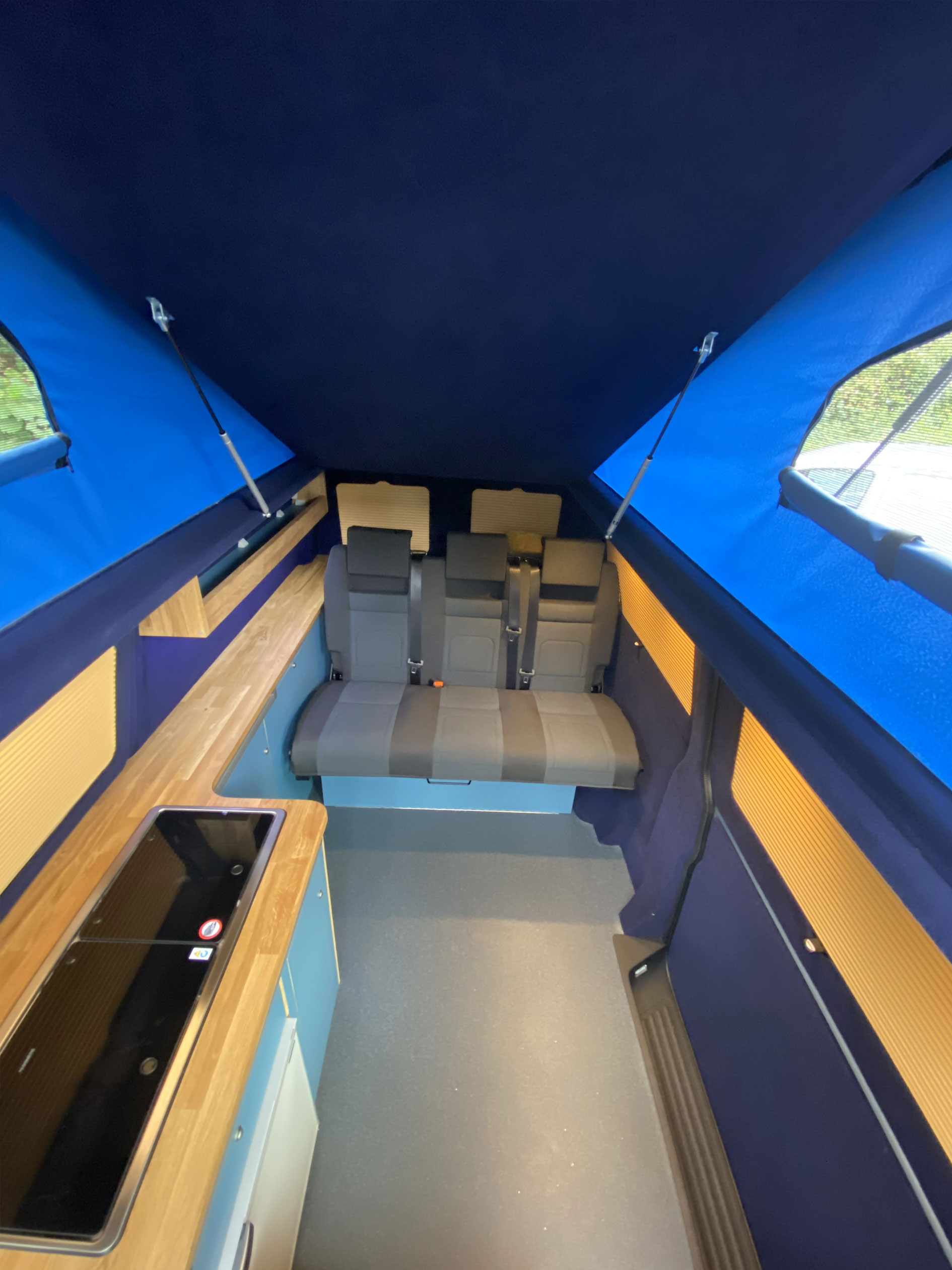 inside a blue fabric campervan elevating roof